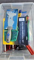 Photo showing Diane's branded plastic-handled scraper in original packaging along with Neway 13-piece high speed drill bit set and other hand tools in a plastic tote.