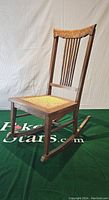 Full front-side view of oak rocking chair showing frame, cane seat and rockers