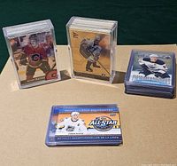 Various hockey cards including two stacks in plastic holders and a stack loose; cards show different NHL players in team uniforms from 2001 McDonald's and 2016 Tim Hortons series