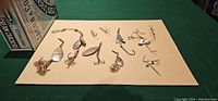 Set of nine vintage fishing lures arranged on a beige surface with Jacob & Company cracker tin to the side