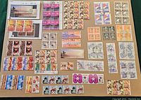Photo showing an assortment of used Hong Kong China stamps including corner blocks and partial sheets laid out on a flat surface.