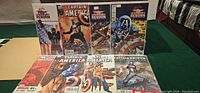Photo showing all eight sealed and carded Captain America comics arranged in two rows, featuring various covers including Captain America Reborn and others.