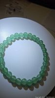 Top view of natural green aventurine bead bracelet lying flat showing full circular shape and bead arrangement.