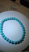 Front view of natural turquoise bead stretchy bracelet laid flat in a loop showing bead color and pattern detail.