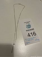 Full view of necklace with pendant and auction lot card