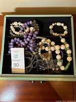 Top view of all jewelry pieces arranged inside a drawer with a MaxSold auction tag visible.