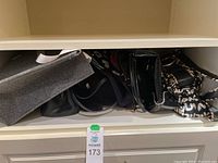 Overview of shelf showing nine assorted purses and bags