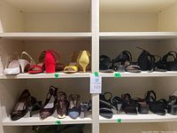 Shoes lot of 12 pairs, various styles and colors, shelved in white cubby.