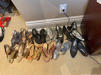 Twelve pairs of women's shoes arranged on floor showing variety of styles and colors.