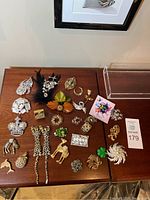 Overhead shot of full assortment of brooches on wood surface