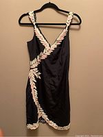 Black sleeveless sheath dress trimmed with pastel leaf embroidery