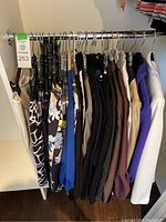 Rack of assorted women’s garments including skirts and tops in assorted colors hung on clothing rod