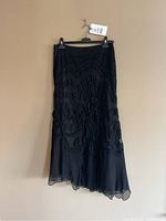 Black tiered chiffon midi skirt on hanger