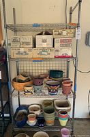 Full view of the chrome shelving rack loaded with various boxes and ceramic pots, showing wire shelves and tubular posts.