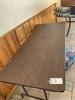 Top view of the folding table showing wood laminate surface and stains.