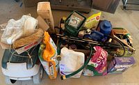 Wide view of all gardening supplies including bottles, bags, twine, hose fittings, and tools in a box