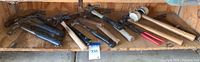 Wide view photo showing all 14 hammers and mallets laid out on a wooden shelf against plywood backing in a container. Variety of handle materials and hammer types present.