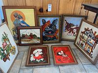 Full view of all 8 framed art pieces arranged on floor showing their varied styles including thread art, animal paintings, and print.
