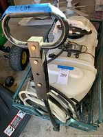 Photo of wagon handle, attached sprayer tank, and hoses inside wagon
