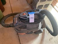 Side view of the Rigid shop vac showing dust and handle with hose attached