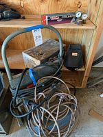 Full view of the Miller welding machine with cables, clamps, and metal cart