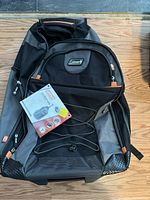 Front view of the Coleman Adventure backpack showing front elastic bungee, Coleman logo, and multiple pockets.