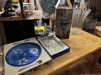 Wide view of both serving dishes, one blue and one clear, and two crystal vases including one in its original box.