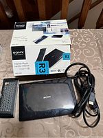 Sony NSZ-GA7 internet player device, power cord, keyboard remote, and original box.