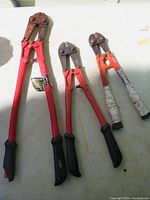 Front view of three bolt cutters in sizes 24", 18", and 14" with red handles and rubber grips, showing surface rust and missing screw on largest cutter.