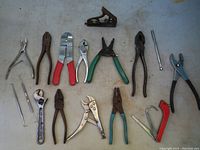 Full lot overview showing all 15 hand tools including pliers, wrenches, and a spirit level, arranged on a light surface.