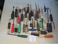 Top view of 46 screwdrivers spread on a surface showing different handle colors, types and sizes