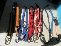 View of all eight straps laid out on a surface showing various colors and types of metal hooks
