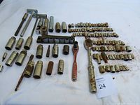 Top view of the 132 piece socket set including sockets, two ratchets, and extensions arranged on white cloth. Tools show signs of use and minor surface rust.