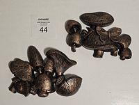 Two dark bronze plastic mushroom wall decor pieces with textured, vintage 70s style including butterfly and moth.