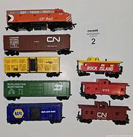 Top-down photo of all 8 HO scale model train cars lined up showing paint and decal details.