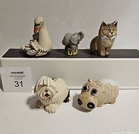 Front view of all 5 animal figurines on display, showing swan, elephant, cat, dog, and hippopotamus