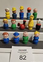 Front view of 14 Fisher-Price Little People figures arranged in three rows showing various characters including humans, animals, and a bird figure.