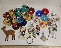 Overview of lot showing colorful flower ornaments, angels, deer figurines, small character ornaments, and silver decorative pieces.