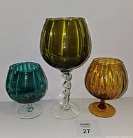 Set of three colored Empoli brandy snifters in green, blue, and amber, shown front view.