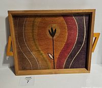 Front view of a vintage wooden serving tray with a hand-painted abstract floral design in warm colors and visible artist signature at bottom left.