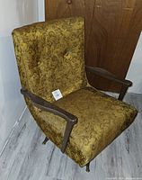 Mid-century modern swivel rocker chair facing camera showing upholstery, armrests, and leg design
