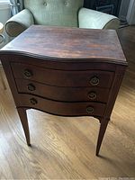 Front view of the Chatham side table showing three curved drawers with metal ring pulls and worn surface
