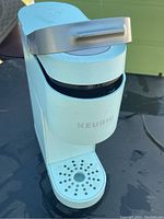 Full view of the Keurig Mini Coffee Machine, light blue with silver handle, showing overall appearance and condition.