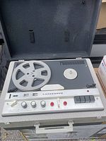 Top view of the Lafayette reel tape machine with one reel mounted and open hard case.