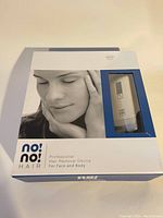 Front of the original box showing the image of a woman’s face and the hair removal device visible through a clear window.