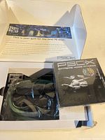 Workout DVD and resistance bands packaged inside white box with printed workout program instructions visible.