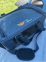 Exterior view of blue JetPaws soft-sided pet carrier with text pattern and shoulder strap.