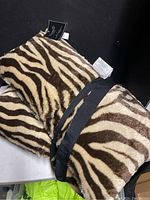 Photo showing two tiger striped pillows with fur texture, tagged new by Thro.