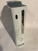 White Xbox 360 console, front view showing disc drive and power button.