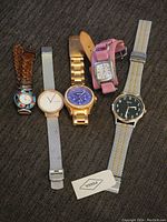 All five watches laid out, showing different styles and bands.